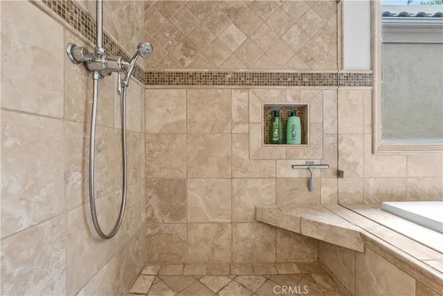 a bathroom with a granite countertop shower a mirror and a bathtub