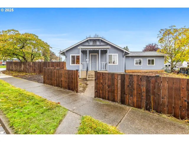 a front view of house with yard and trees in the background
