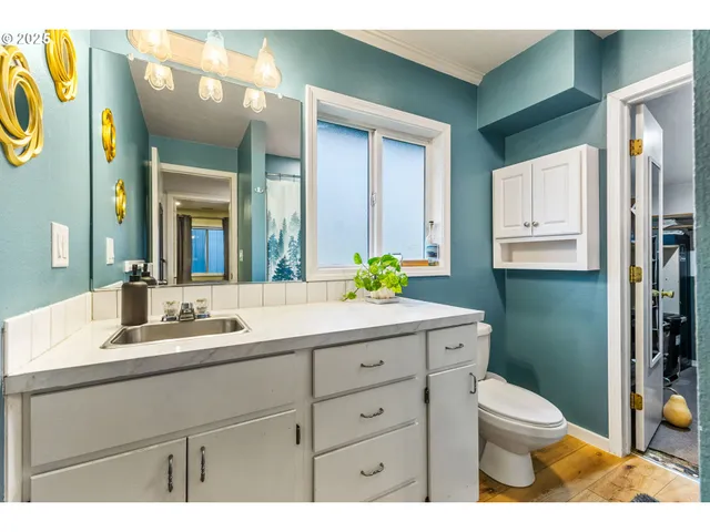 a bathroom with a granite countertop toilet sink and mirror