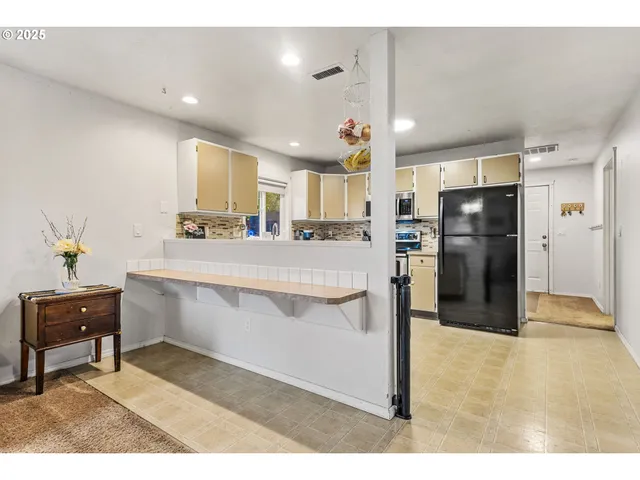 a kitchen with stainless steel appliances kitchen island granite countertop a refrigerator and a sink