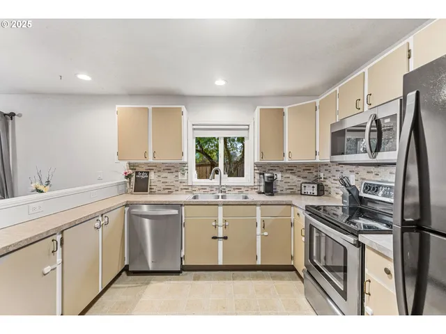 a kitchen with stainless steel appliances granite countertop a sink and stove top oven