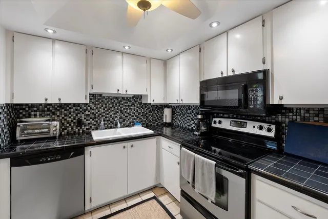 a kitchen with granite countertop a sink and a stove