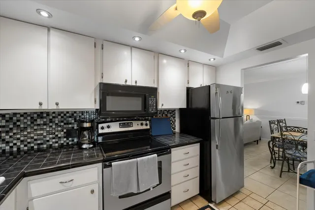 a kitchen with granite countertop a refrigerator and a stove top oven