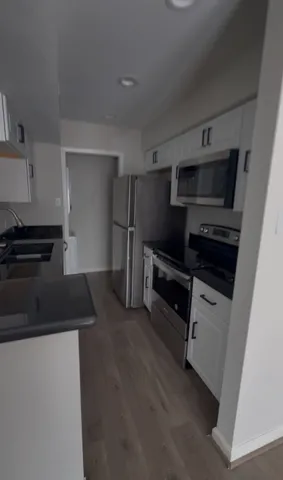 a kitchen with stainless steel appliances a stove a microwave and a refrigerator