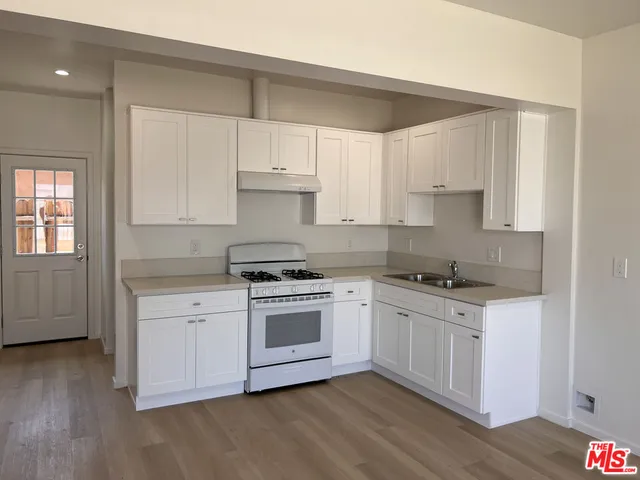 a kitchen with wooden floors and white appliances