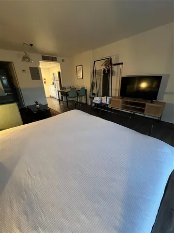 a living room with large flat screen tv and gym equipment