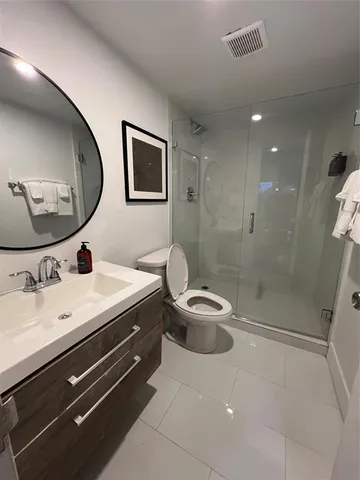 a bathroom with a double vanity sink toilet and shower