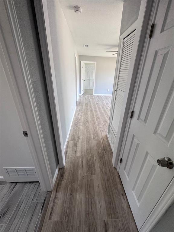 1736 Ransom Terrace Fort Worth, TX 76112 - Photo 20 of 27 Hallway featuring wood-finish flooring, white paneled doors, light grey wall paint, and recessed lighting
