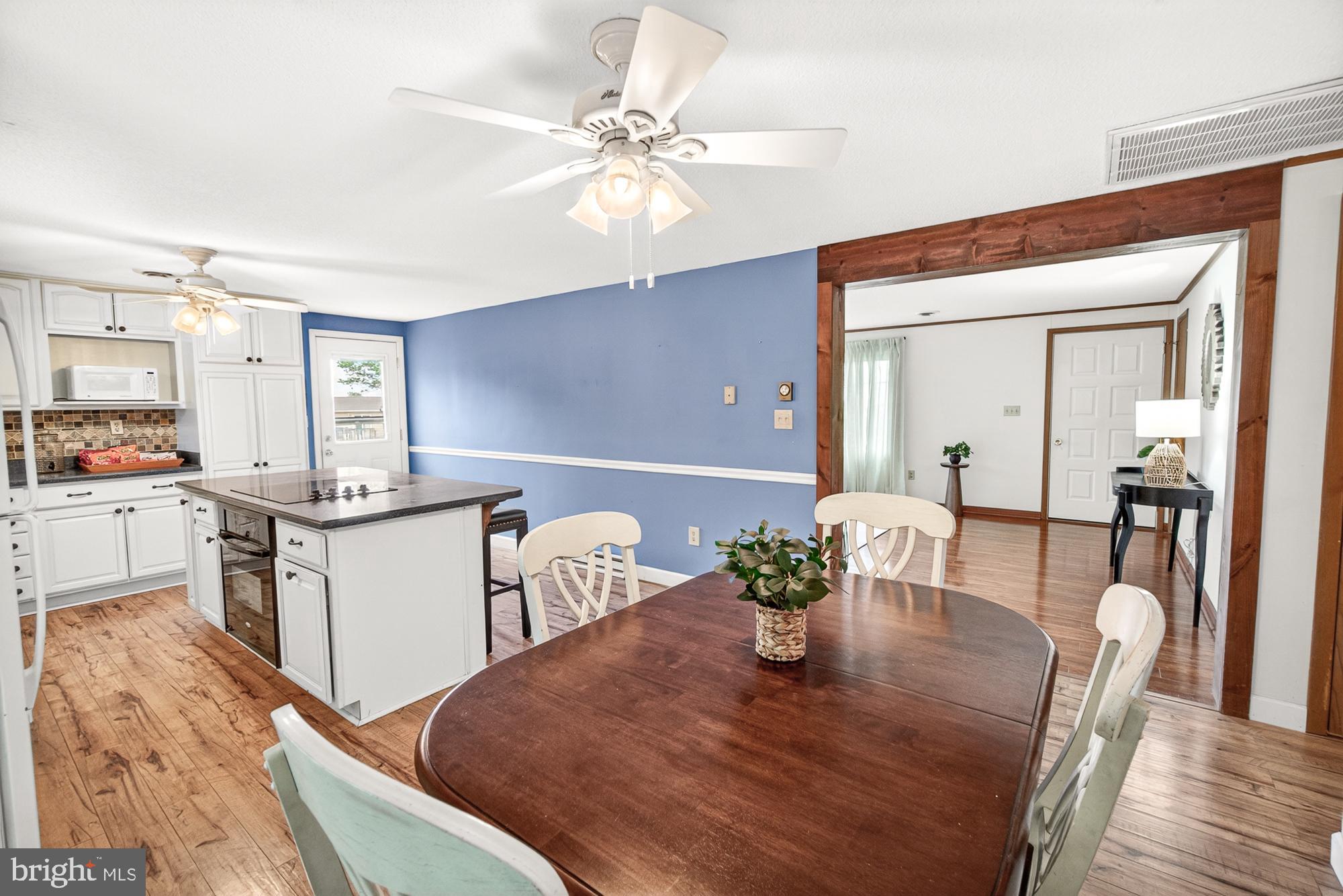 5601 Woodville Road Mount Airy, MD 21771 - Photo 13 of 54 a kitchen with stainless steel appliances granite countertop a table chairs and a refrigerator
