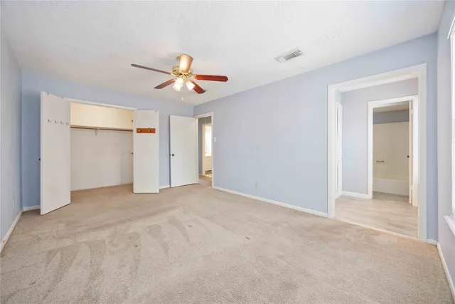 a view of an empty room with a ceiling fan