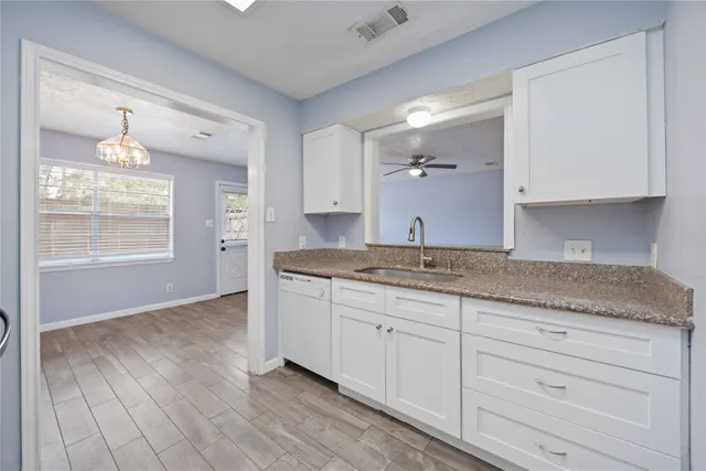 a bathroom with a granite countertop sink and mirror