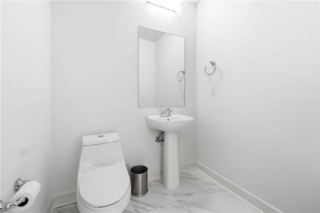 a bathroom with a sink toilet and a mirror