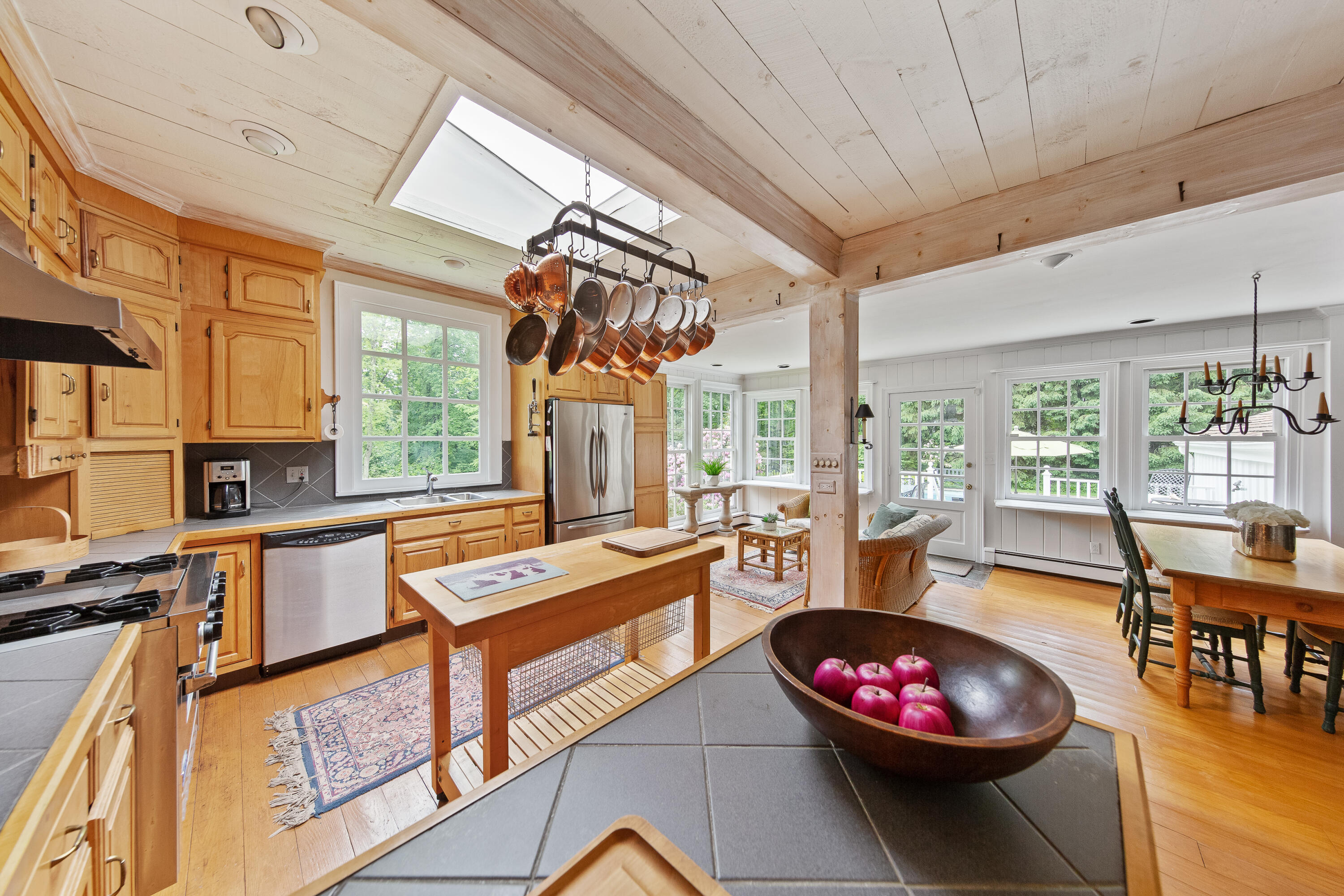 14 Rings End Road Darien, CT 06820 - Photo 14 of 38 a kitchen with a stove a sink and a dining table with wooden cabinet