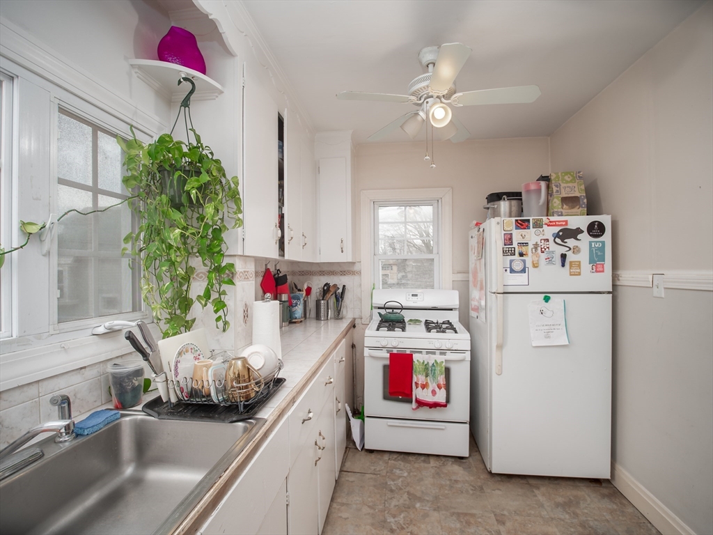 60 Powder House Boulevard, Unit 2 Somerville, MA 02144 - Photo 13 of 42 a utility room with cabinets a washer and dryer