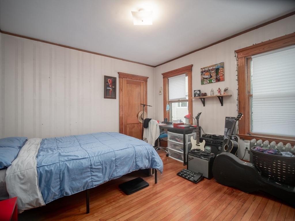 60 Powder House Boulevard, Unit 2 Somerville, MA 02144 - Photo 20 of 42 a bedroom with a bed and wooden floor