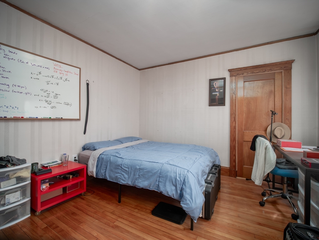 60 Powder House Boulevard, Unit 2 Somerville, MA 02144 - Photo 21 of 42 a bedroom with a bed and wooden floor