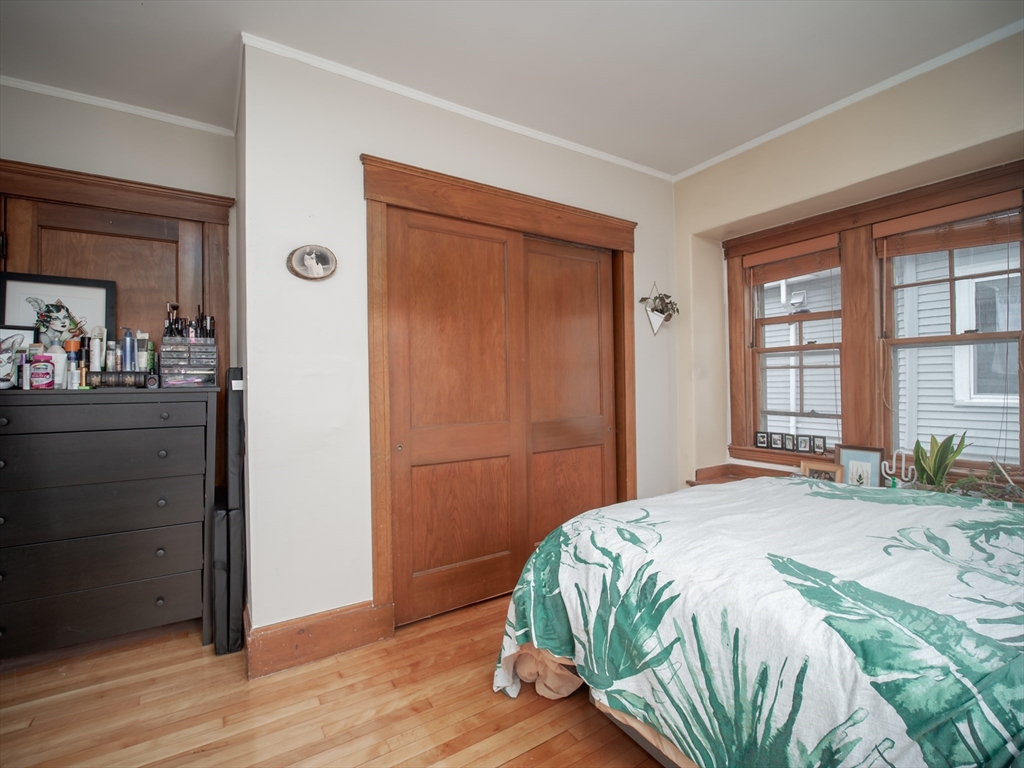 60 Powder House Boulevard, Unit 2 Somerville, MA 02144 - Photo 25 of 42 a bedroom with a bed and a dresser