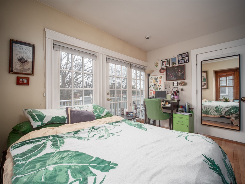 60 Powder House Boulevard, Unit 2 Somerville, MA 02144 - Photo 26 of 42 a bedroom with a bed and wooden floor