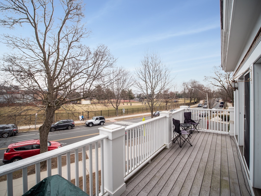 60 Powder House Boulevard, Unit 2 Somerville, MA 02144 - Photo 28 of 42 a view of city from a balcony with wooden floor and fence
