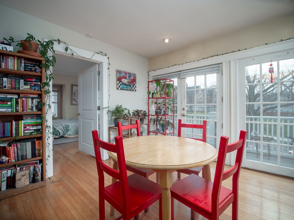 60 Powder House Boulevard, Unit 2 Somerville, MA 02144 - Photo 7 of 42 a view of a dining room with furniture and a book shelf