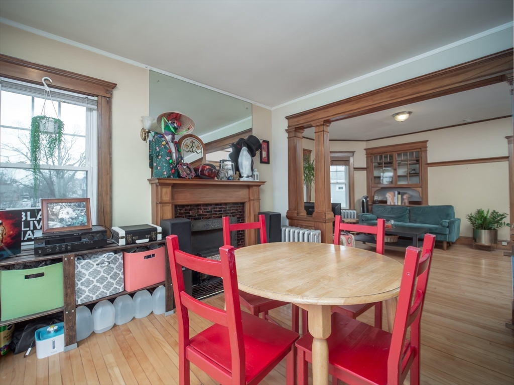 60 Powder House Boulevard, Unit 2 Somerville, MA 02144 - Photo 9 of 42 a view of a dining room with furniture and a fireplace