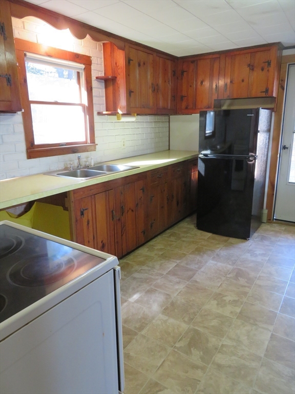 103 King Philip Road Norton, MA 02766 - Photo 6 of 37 a kitchen with a refrigerator and window