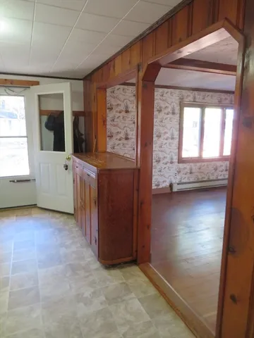 an empty room with window and wooden door