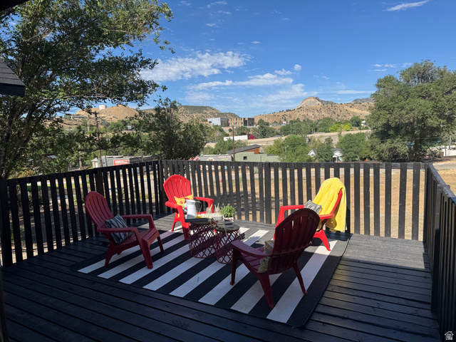 47 B Street Helper, UT 84526 - Photo 4 of 19 Expansive outdoor deck featuring a black wood-finish surface, slatted railing, and a scenic mountain backdrop