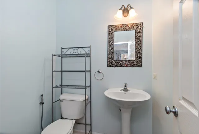 a bathroom with a toilet a sink and mirror