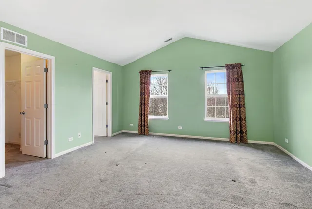 an empty room with windows and closet