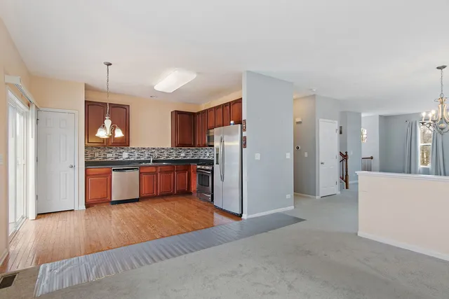 a kitchen with stainless steel appliances granite countertop a refrigerator and a stove