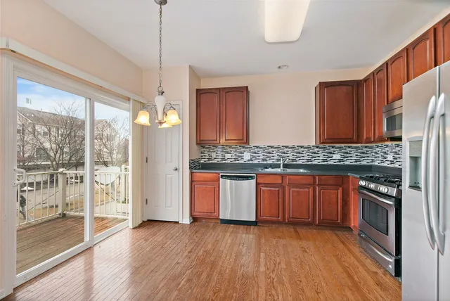 a kitchen with stainless steel appliances granite countertop wooden cabinets a stove a sink and dishwasher