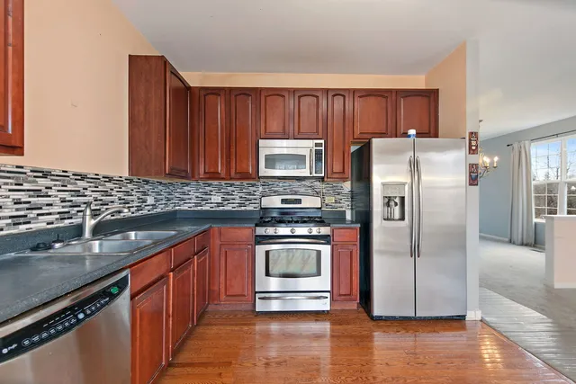 a kitchen with granite countertop a refrigerator and a sink