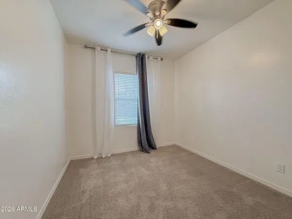 an empty room with closet and a chandelier fan
