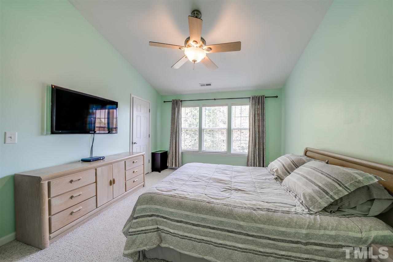 8460 Reedy Ridge Lane Raleigh, NC 27613 - Photo 14 of 22 a bedroom with a large bed and a flat tv screen on dresser