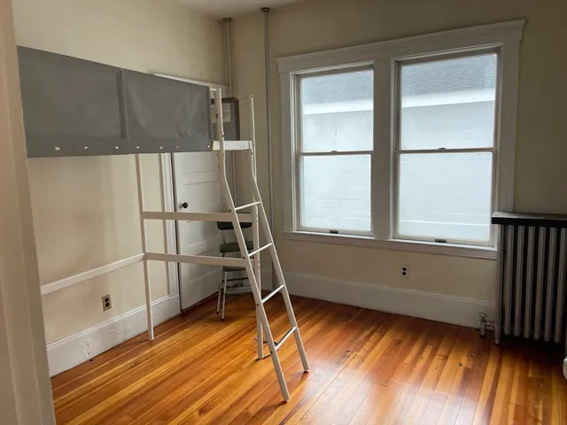 a view of a storage and utility room with wooden floor