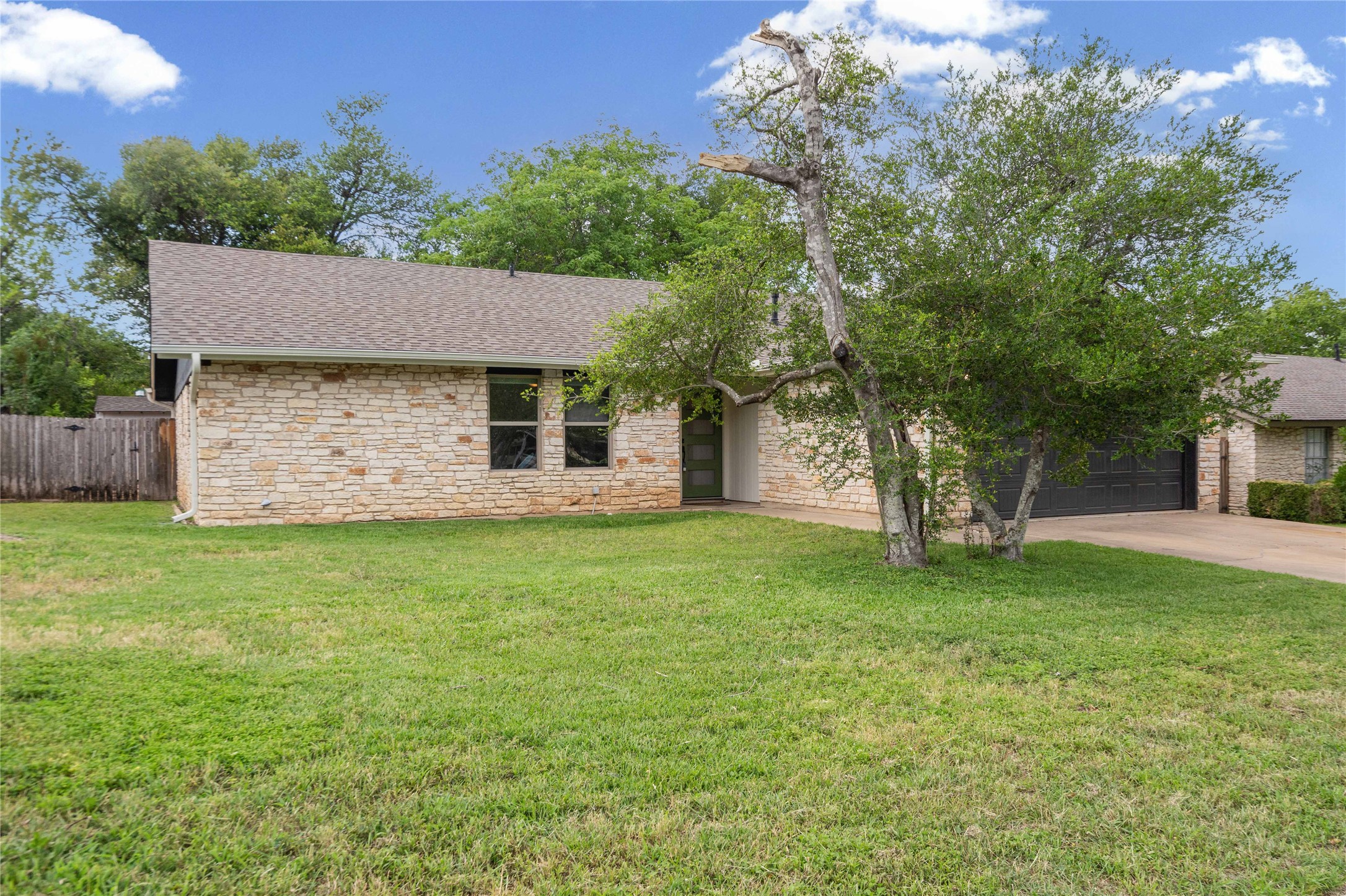 810 Stillhouse Spring Round Rock, TX 78681 - Photo 15 of 18 A well-maintained lawn welcomes visitors to this charming stone-clad residence with a double garage.
