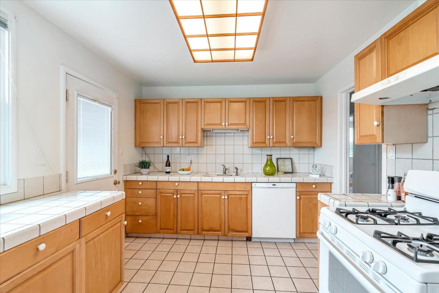 1159 De Solo Drive Pacifica, CA 94044 - Photo 20 of 45 a kitchen with a stove a sink wooden floor and a window