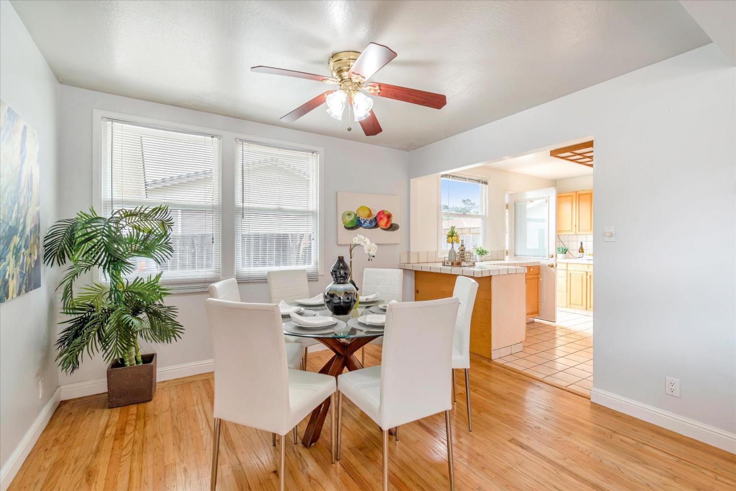 1159 De Solo Drive Pacifica, CA 94044 - Photo 24 of 45 a dining room with wooden floor a chandelier fan a glass table and chairs