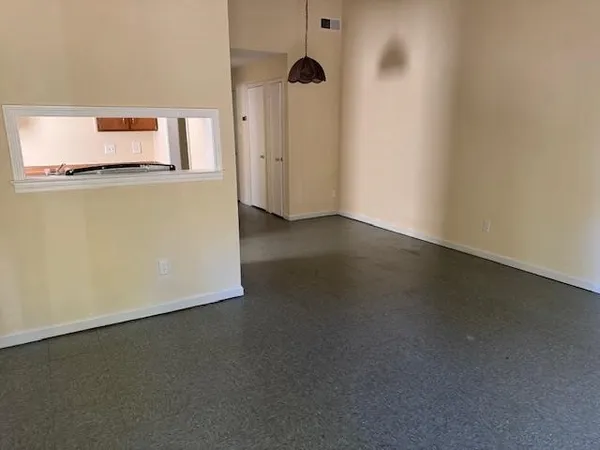 a view of a room with wooden floor and a ceiling fan