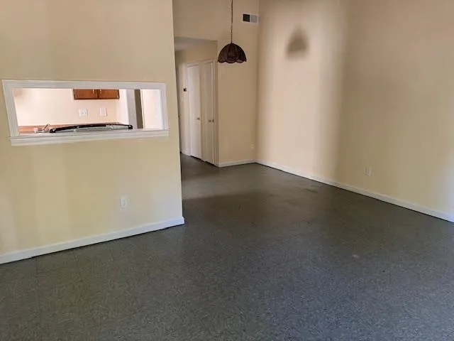 a view of a room with wooden floor and a ceiling fan