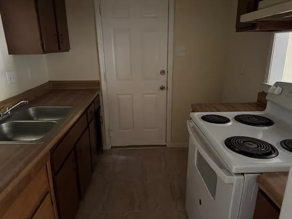 a kitchen with a sink stove and refrigerator