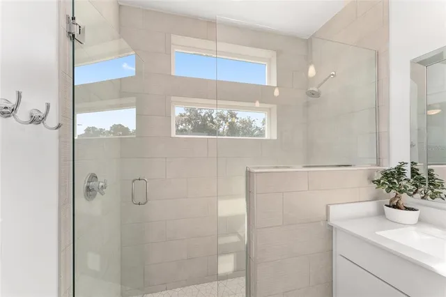 a bathroom with a sink a toilet a large mirror and shower