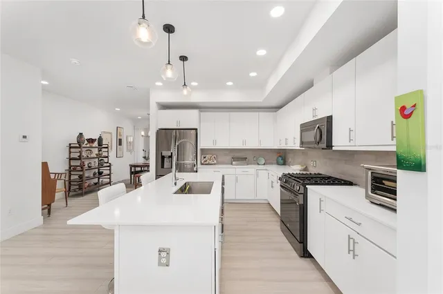 a kitchen with stainless steel appliances kitchen island granite countertop a sink and cabinets
