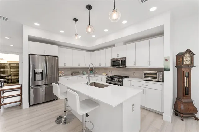 a kitchen with stainless steel appliances a refrigerator stove and microwave