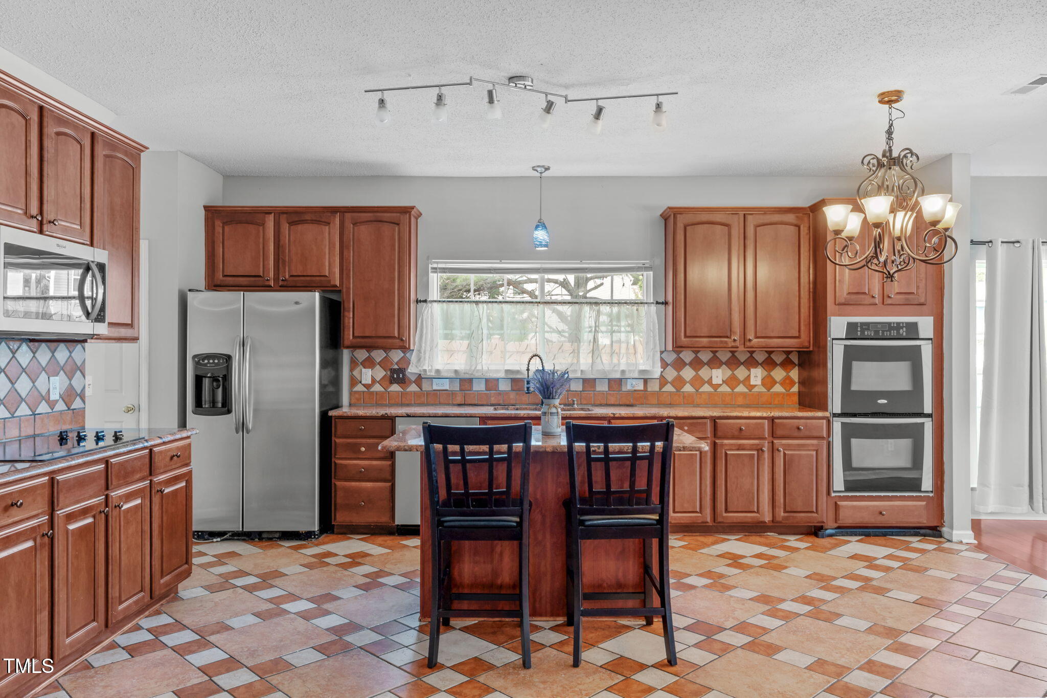 760 Stackhurst Way Wake Forest, NC 27587 - Photo 13 of 37 a kitchen with refrigerator cabinets dining table and chairs