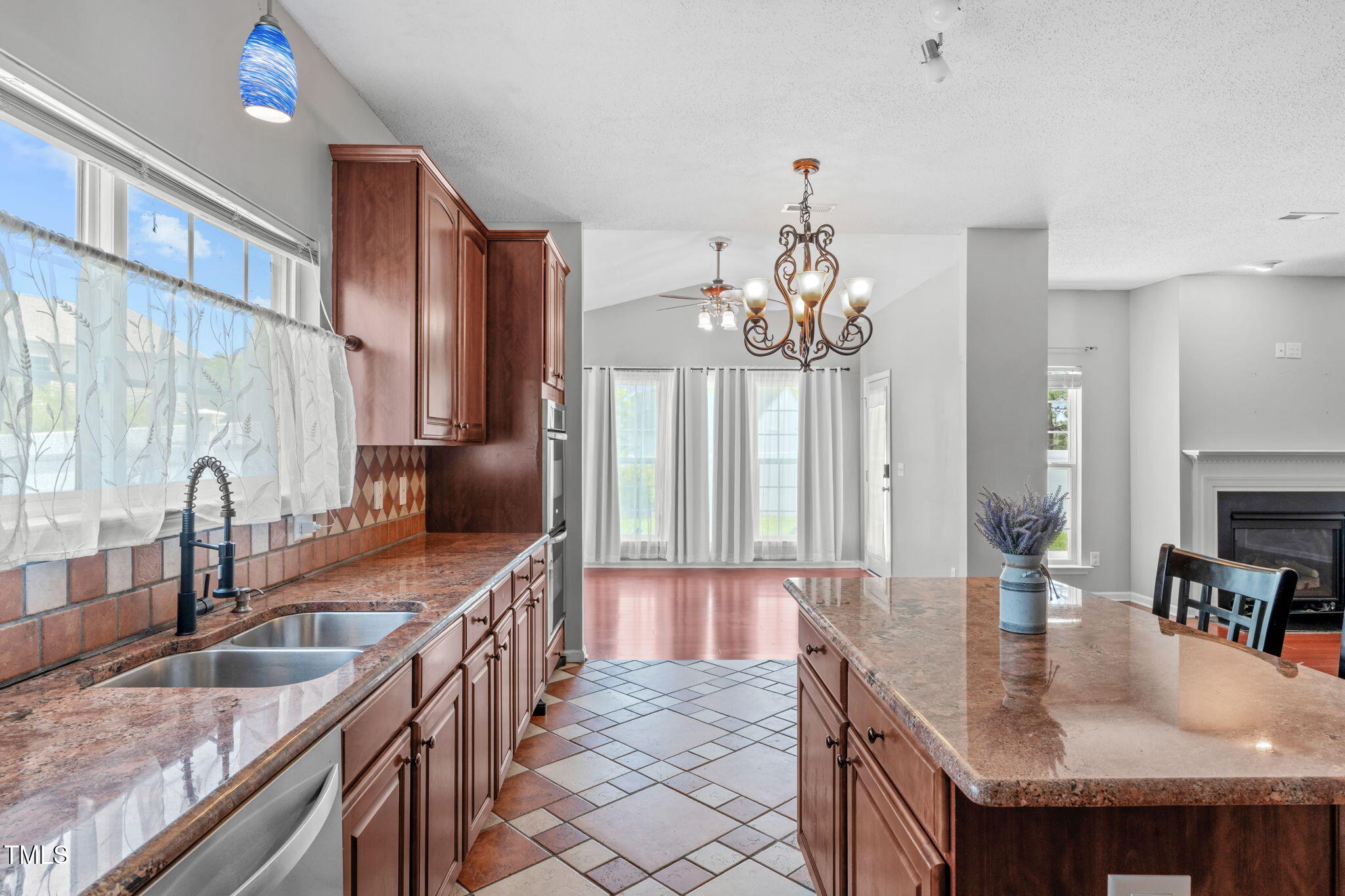 760 Stackhurst Way Wake Forest, NC 27587 - Photo 14 of 37 a kitchen with granite countertop a sink a counter top space and living room view