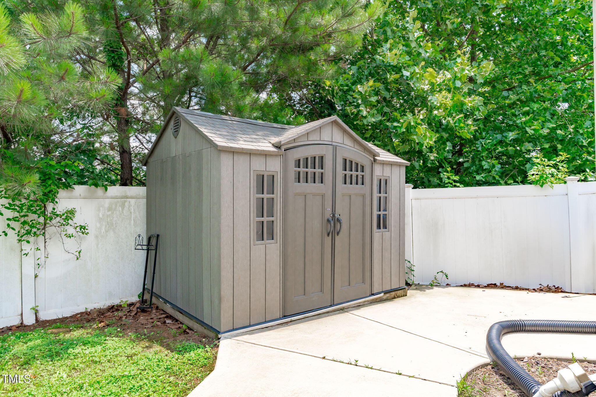 760 Stackhurst Way Wake Forest, NC 27587 - Photo 34 of 37 a white house covered with tall trees in front of it