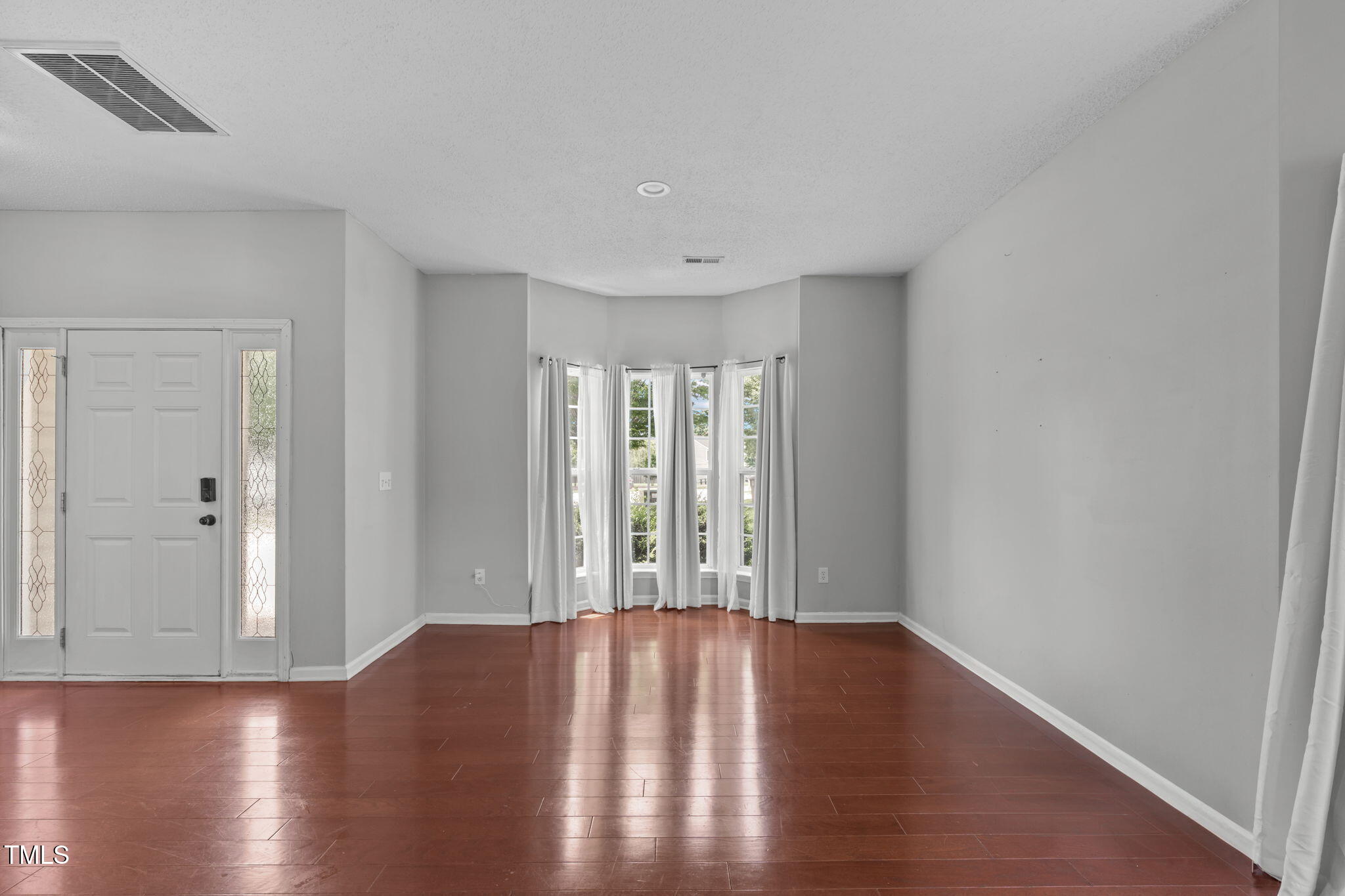760 Stackhurst Way Wake Forest, NC 27587 - Photo 8 of 37 a view of an empty room with wooden floor and a window