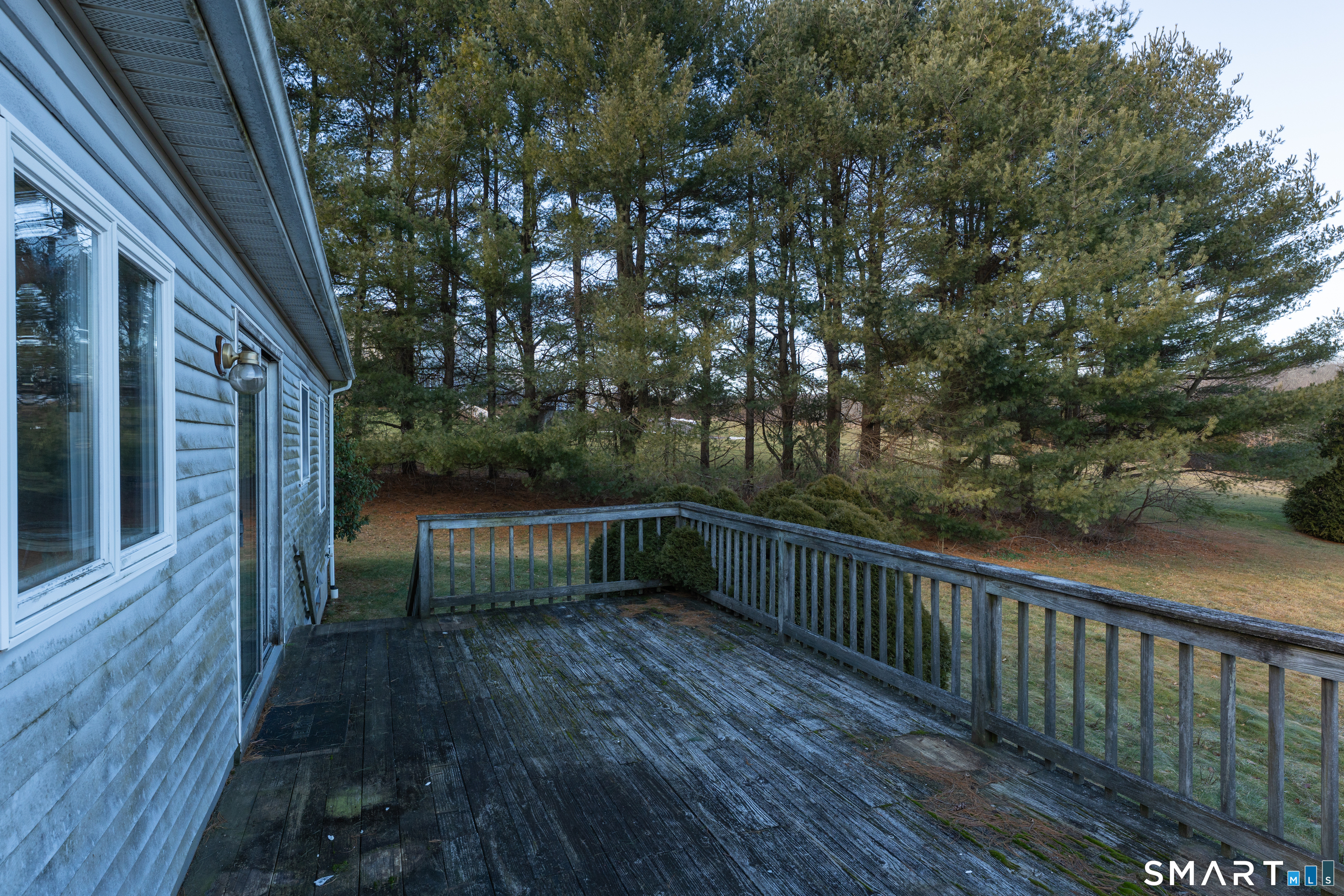 250 Elm Street Guilford, CT 06437 - Photo 16 of 25 a balcony with wooden floor and trees